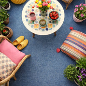 Colorful living room with a patterned rug, furniture, and decorative items.